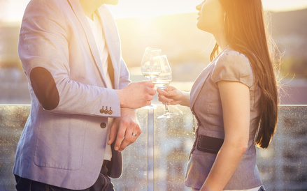 Beautiful young couple drinking wine on a terrace of a bar